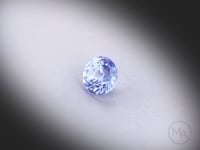 Vidéo d’un saphir bleu naturel rond facetté de 1.24 ct, originaire du Sri Lanka, de couleur bleu léger, tournant sur un fond gris clair.