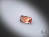 Vidéo d’une tourmaline bicolore naturelle rectangle à pans coupés facettée de 1.50 ct, originaire du Congo, aux couleurs bicolores prononcées, tournant sur un fond gris clair.