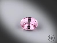 Vidéo d’un spinelle rose naturel ovale facetté de 2.25 ct, originaire de Mahenge en Tanzanie, de couleur rose prononcé, gemme tournant sur un fond gris clair.