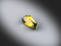 Vidéo d’un saphir bicolore naturel d'Australie facetté de forme abstraite de 1.58 ct, couleurs soutenues, tournant sur un fond gris clair. Aucun traitement