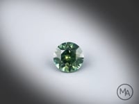 Vidéo d’un saphir teal naturel rond facetté de 1.36 ct, originaire d'Australie, de couleur vert-bleuté soutenu, rotation sur un fond gris clair.