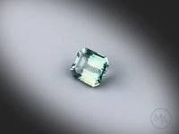 Vidéo d’un saphir teal naturel non traité rectangle à pans coupés facetté de 1.19 ct, originaire de Tanzanie, de couleur bleu-vert prononcé, tournant sur un fond gris clair.