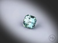 Vidéo d’un saphir teal naturel carré à pans coupés facetté de 2.12 ct, originaire de Tanzanie, de couleur bleu-vert prononcé, tournant sur un fond gris clair. Gemme non traitée.