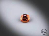 Vidéo d’un Grenat Hessonite naturel coussin rectangle facetté de 1.32 ct, originaire du Sri Lanka, de couleur orange-brun et présentant un aspect sirupeux, pierre fine tournant sur un fond gris clair.
