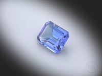Vidéo d’une tanzanite naturelle rectangle à pans coupés facettée de 4.44 ct, chauffée, de couleur bleu-violet prononcé, tournant sur un fond gris clair.