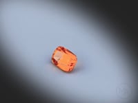 Vidéo d’un grenat spessartite naturel coussin rectangle facetté de 1.29 ct, originaire du Nigéria, de couleur orange soutenu, rotation sur un fond gris clair. Gemme non traitée.
