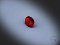 Vidéo d’une opale de feu naturelle ovale facettée de 0.65 ct, originaire du Mexique, de couleur rouge-orangé profond, tournant à 360 degrés sur un fond gris clair.