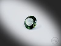 Vidéo d’un saphir vert naturel rond facetté de 2.29ct, originaire d’Australie, de couleur vert-jaune soutenu, rotation sur un fond gris clair. Aucun traitement, livré avec certrificat.