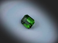 Vidéo d’une tourmaline chrome verte naturelle rectangle à pans coupés facettée de 2.85 ct, originaire de Tanzanie, de couleur vert profond, rotation sur un fond gris clair. Aucun traitement.