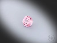 Vidéo d’un saphir rose naturel non chauffé rond facetté de 0.57 ct, originaire du Sri Lanka, de couleur rose prononcé, tournant sur un fond gris clair.