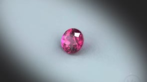 Vidéo d’un saphir rose naturel rond non traité facetté de 0.47 ct, originaire de Madagascar, de couleur rose-rouge profond, tournant sur un fond gris clair.