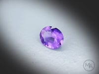 Vidéo d’une Améthyste naturelle ovale facettée de 1.54 ct, originaire du Brésil, de couleur violet-rosé soutenu, pierre fine tournant sur un fond gris clair.