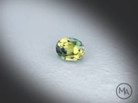 Vidéo d’un Saphir bicolore naturel ovale facetté de 1.18 ct, originaire d’Australie, de couleur bicolore soutenu, pierre précieuse tournant sur un fond gris clair.