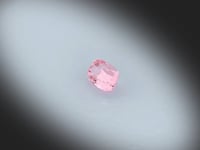 Vidéo d’un Spinelle rose naturel coussin rectangle facetté de 1.29ct, originaire de Tanzanie, de couleur rose-brun prononcé, gemme tournant sur un fond gris clair.