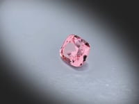Vidéo d’un Grenat Malaya naturel coussin rectangle facetté de 2.15 ct, originaire de Madagascar, de couleur rose-orangé soutenu, pierre fine rare tournant sur un fond gris clair.