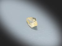 Vidéo d’un Saphir jaune naturel abstrait facetté de 0.72 ct, originaire du Sri Lanka, de couleur jaune léger, pierre précieuse originale tournant sur un fond gris clair.