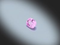 Vidéo d’un Saphir rose naturel coussin rectangle facetté de 1.00 ct, originaire de Madagascar, de couleur rose-violet soutenu, pierre précieuse tournant sur un fond gris clair.