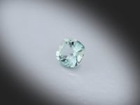 Vidéo d’un Saphir Teal naturel coussin carré facetté de 0.70 ct, originaire de Madagascar, de couleur bleu-vert légère, pierre précieuse tournant sur un fond gris clair.