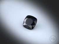 Vidéo d’un Spinelle noir naturel coussin carré facetté de 4.28 ct, originaire de Thaïlande, de couleur noir opaque, pierre précieuse tournant sur un fond gris clair.