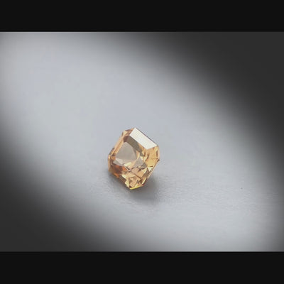 Vidéo d’un zircon naturel rectangle à pans coupés facetté de 1.65 ct, originaire de Tanzanie, mettant en valeur sa teinte brun orangé prononcée et ses reflets lumineux.