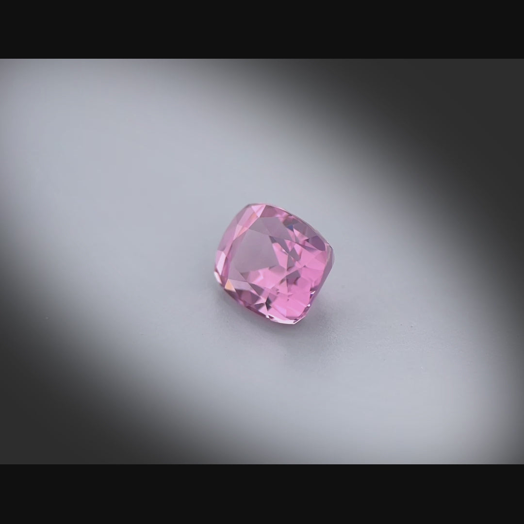 Vidéo d’un spinelle rose naturel coussin rectangle facetté de 2.09 ct, originaire de Luc Yen au Vietnam, de couleur rose-violet soutenu, tournant sur un fond gris clair.